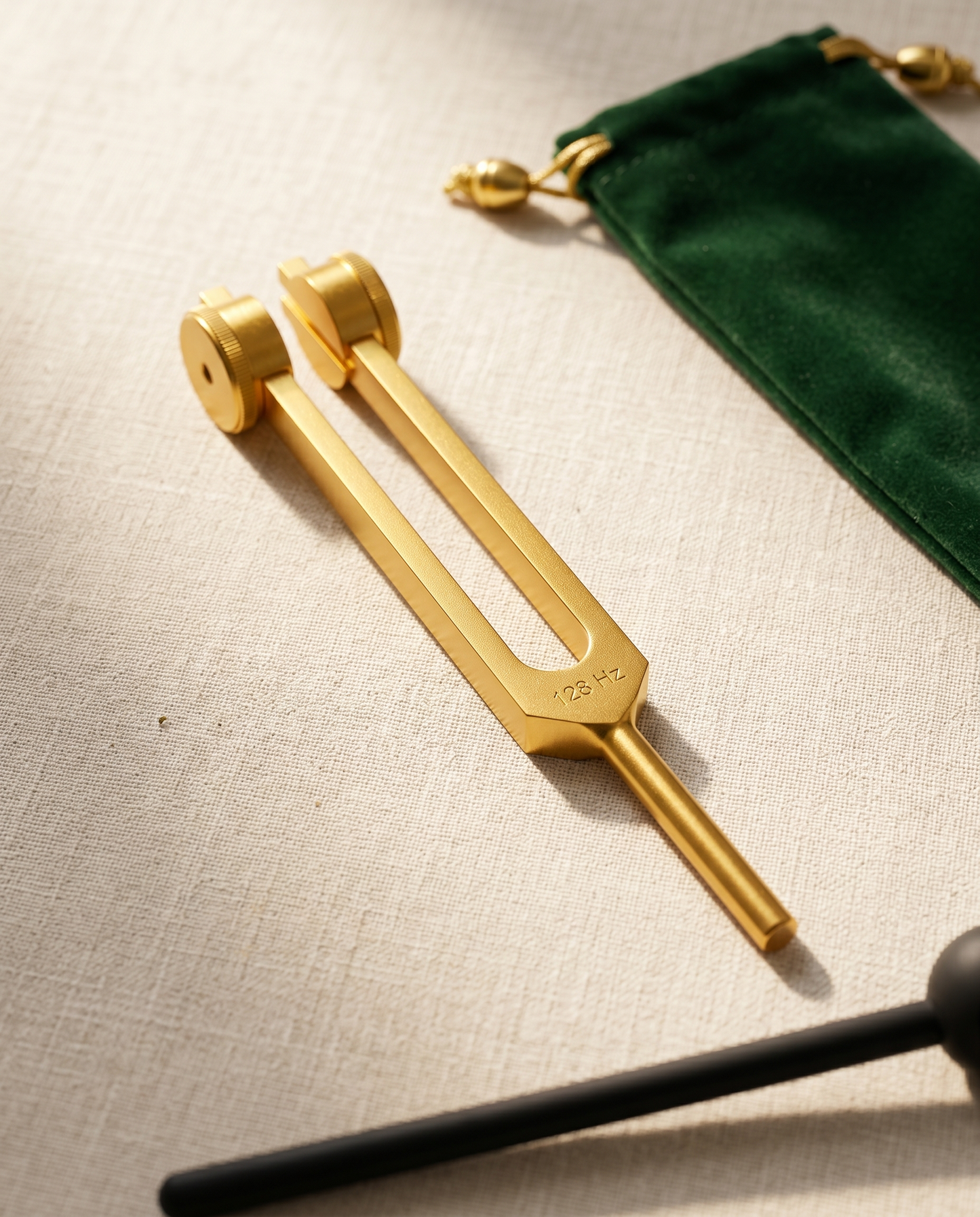 128 Hz Body Healing tuning fork — editorial linen flat-lay with champagne morning light